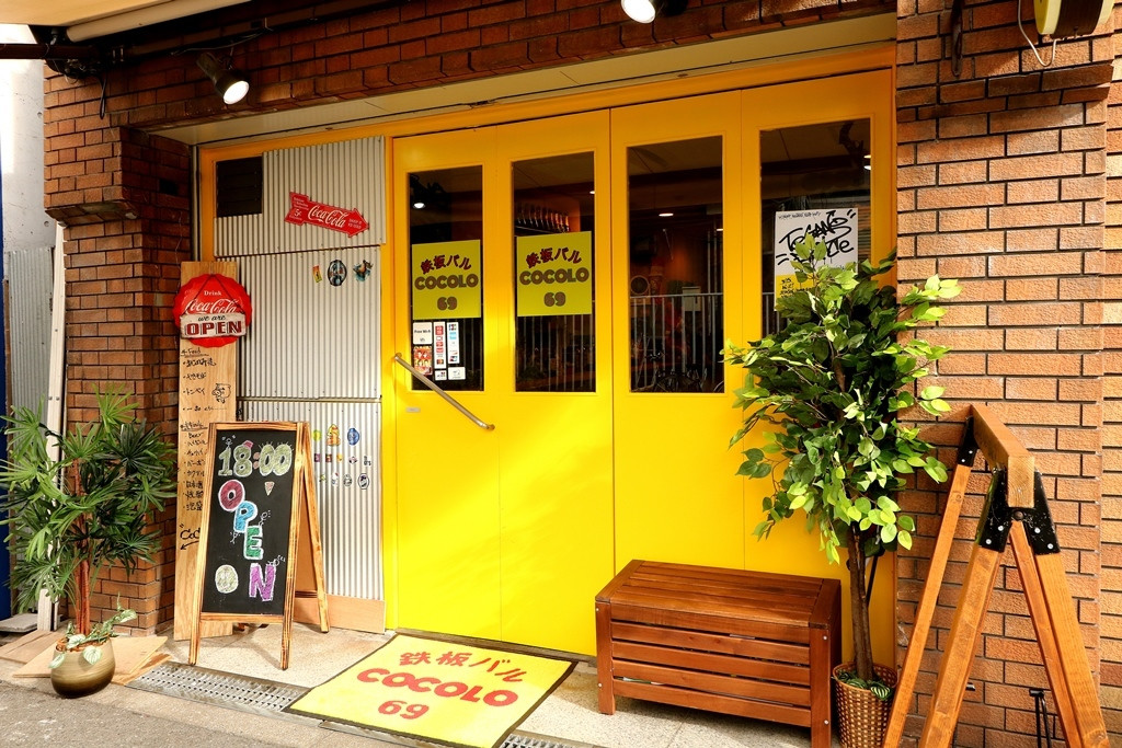 黄色扉が特徴的なお店の外観